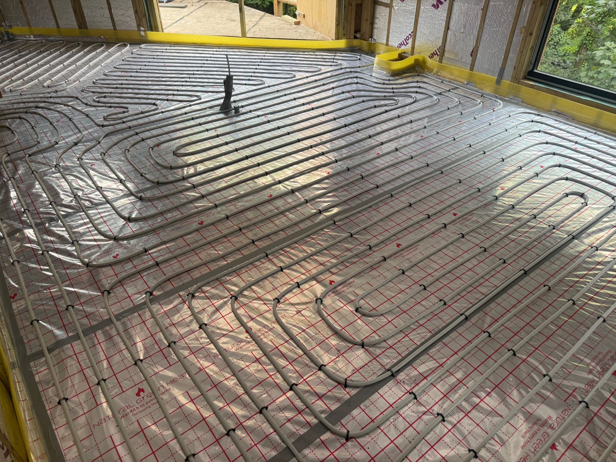 Full screed underfloor heating pipework laid for an air source heat pump system
